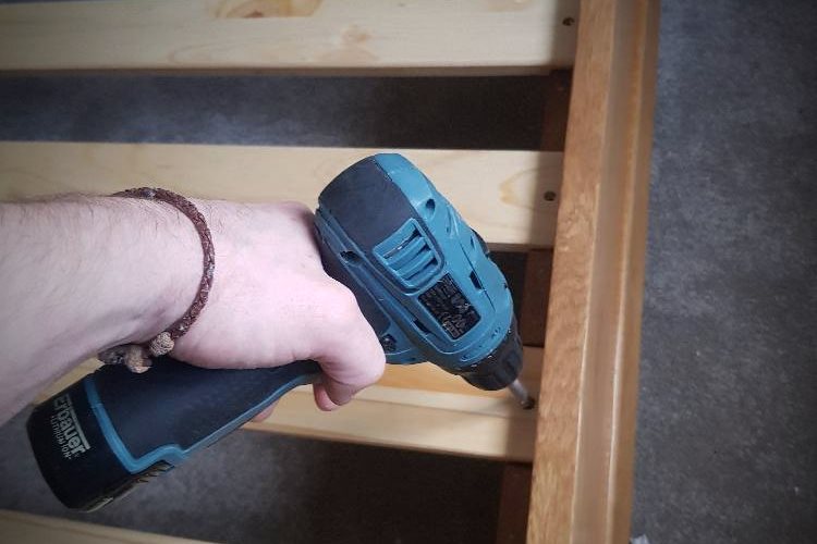 The assembly of bed slats on a wooden bed frame