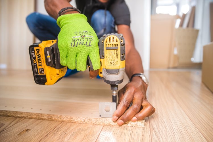 Technician assembling hinges on a wooden cabinet panel