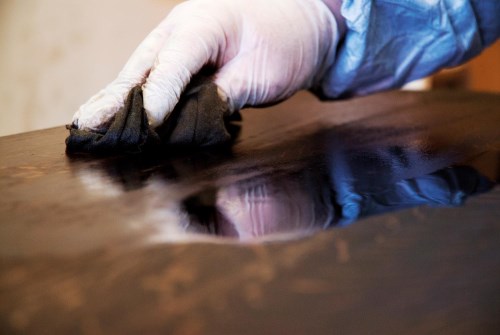 technician applying french polish to a table